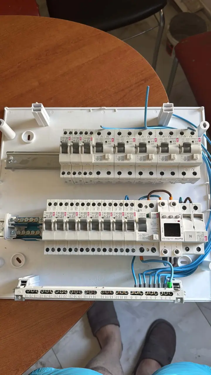 Tablou electric cablat, pus pe o masă, cu două rânduri de aparate și fire albastre grupate